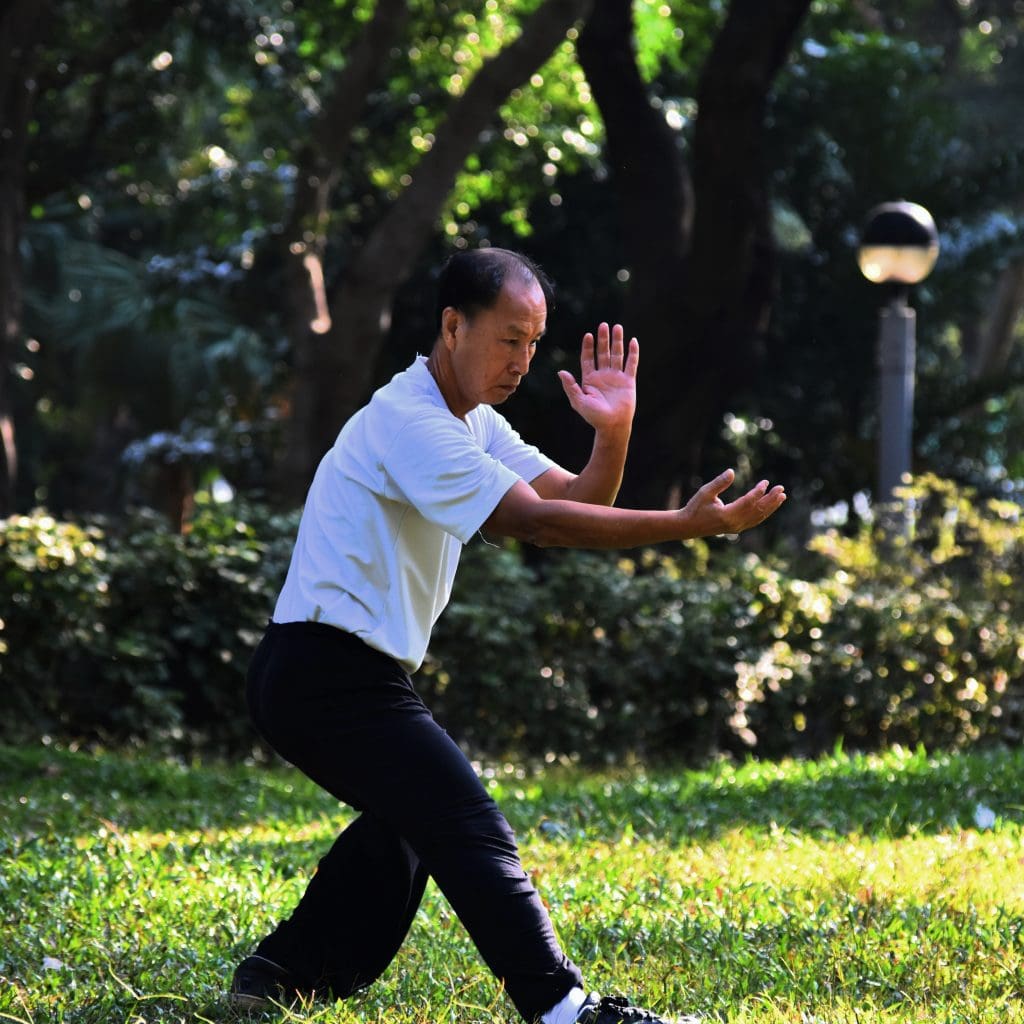 man practicing tai chi for seniors in the sun outside