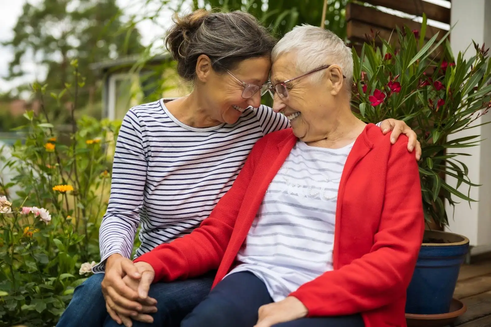 A senior mom and daughter smiling forehead to forehead while discussing a caring for aging parents checklist at Eastcastle Place.