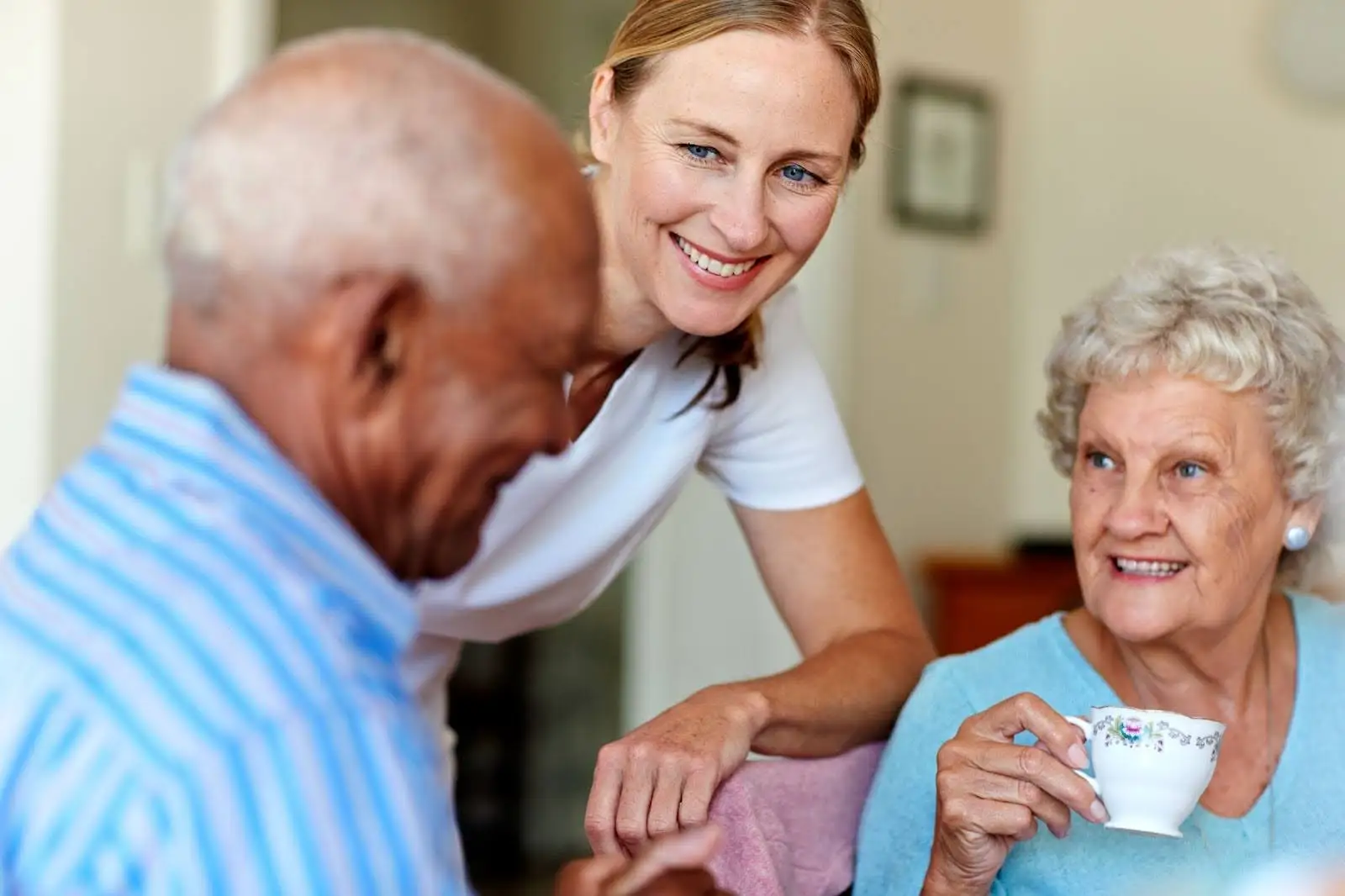 A daughter smiling next to her senior parents while discussing a caring for aging parents checklist at Eastcastle Place