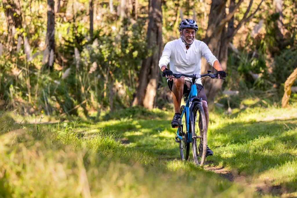 A senior man biking on a trail in Milwaukee, WI, near Eastcastle Place.