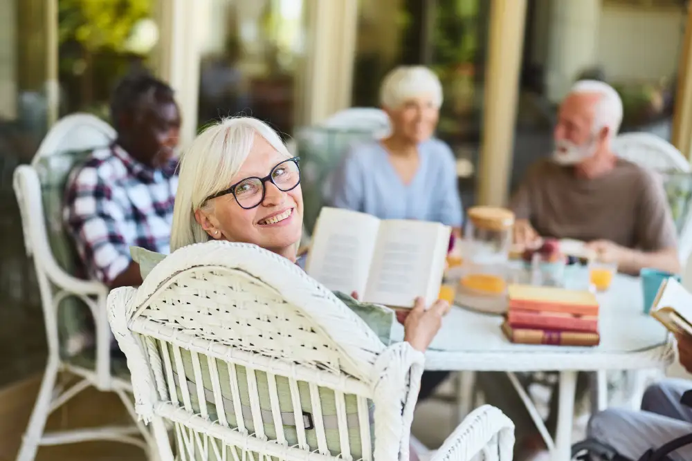 a group of seniors sitting outside reading books