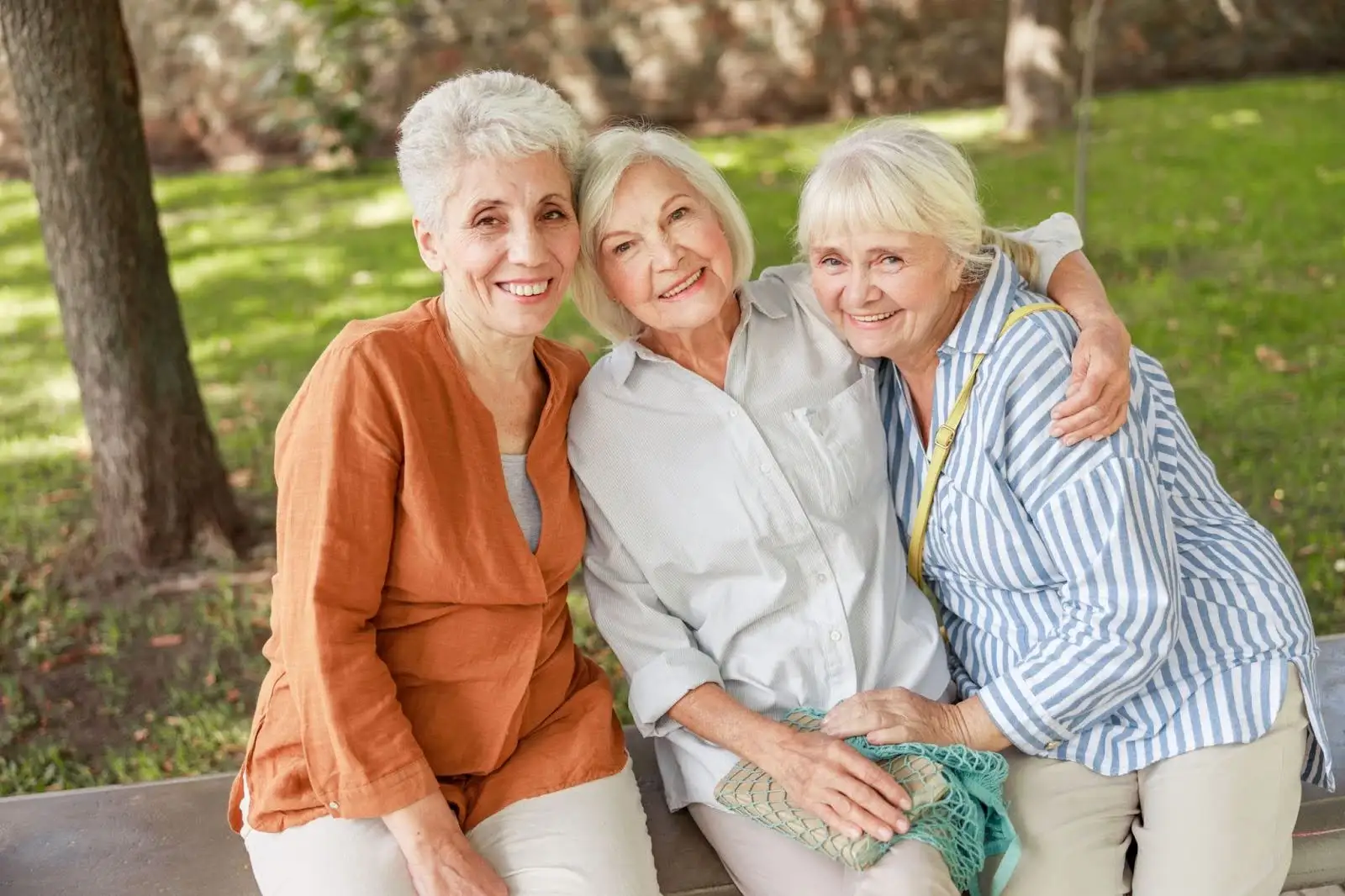 There senior women smiling outside of Eastcastle Place while discussing life plan community costs.